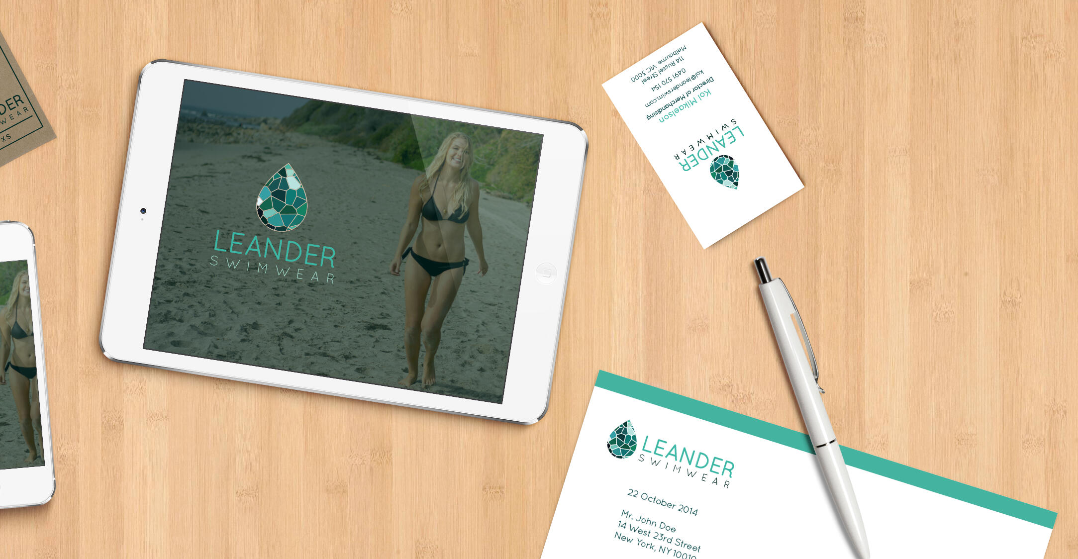 More flat lay mockups of the identity suite scattered on a wood background.