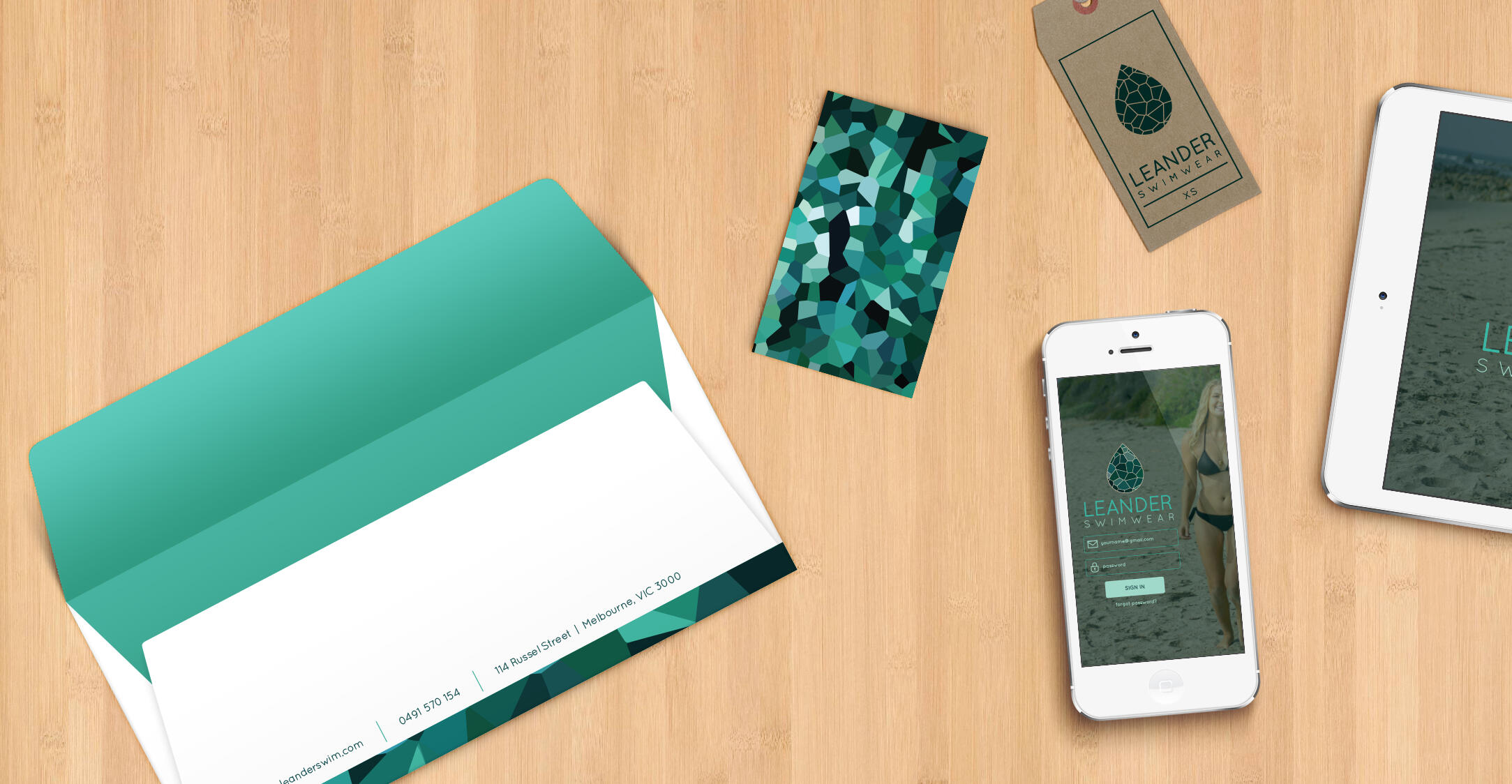 More flat lay mockups of the identity suite scattered on a wood background.