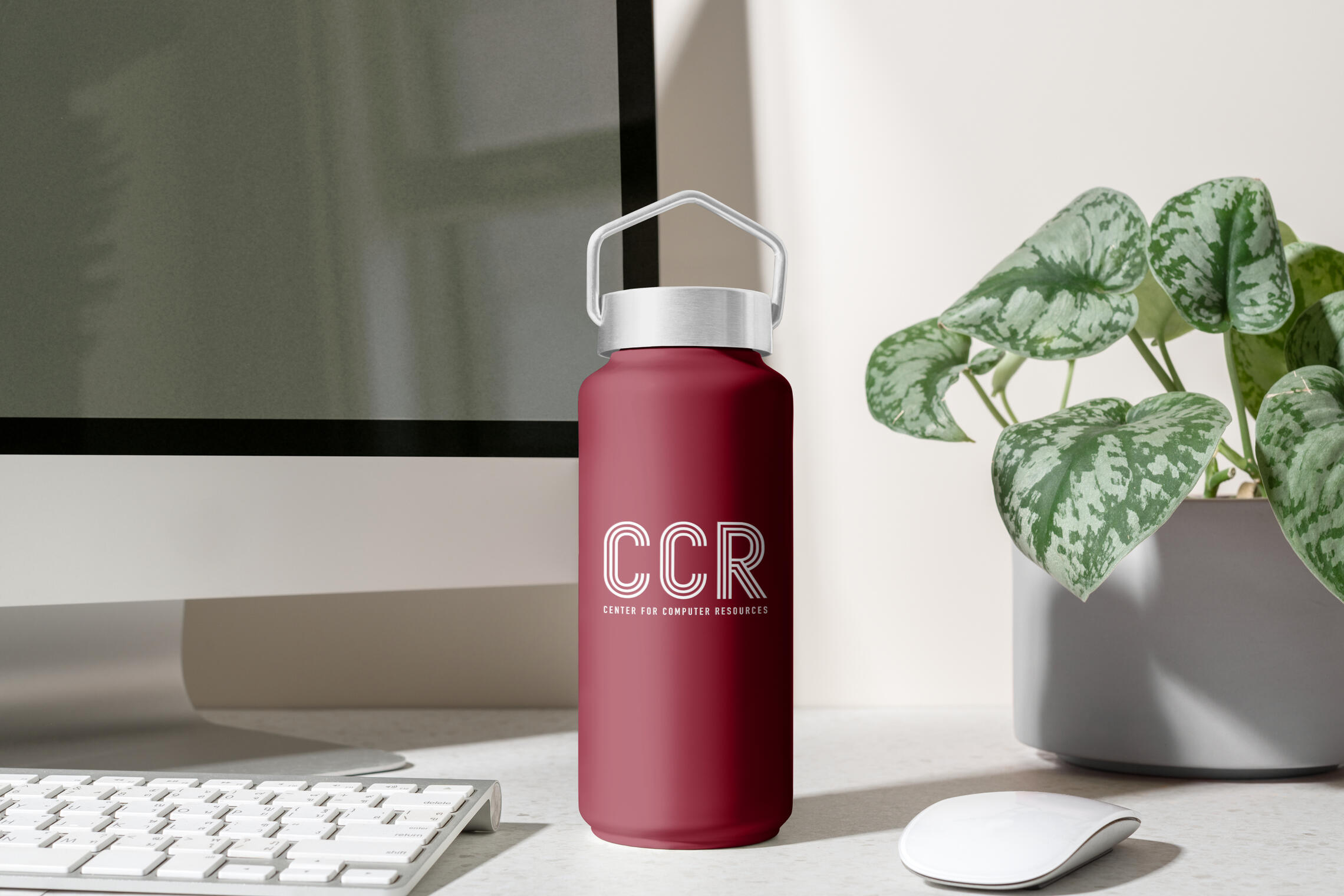 A mockup of the new logo in action on some company merch. A CCR burgundy water bottle with the new primary logo etched into the stainless steel.